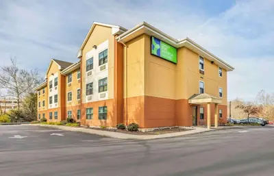a large yellow building with a green sign on it at Extended Stay America Select Suites - Philadelphia - Malvern - Great Valley in Malvern