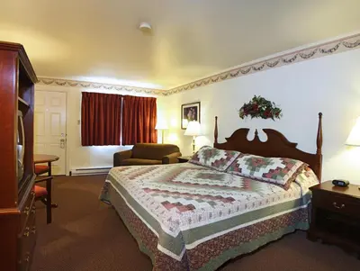 a hotel room with a bed and a chair at Amish Country Motel in Bird in Hand