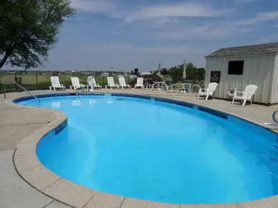 a large blue swimming pool with chairs around it at Amish Country Motel in Bird in Hand