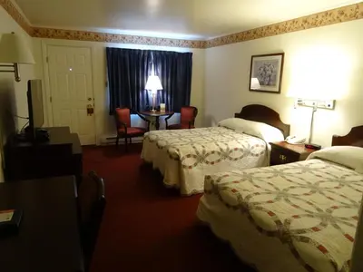 a hotel room with two beds and a table at Amish Country Motel in Bird in Hand