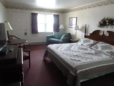 a hotel room with a bed and a chair at Amish Country Motel in Bird in Hand