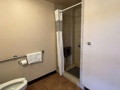 a bathroom with a shower and a toilet at Travelodge by Wyndham Hershey in Hershey