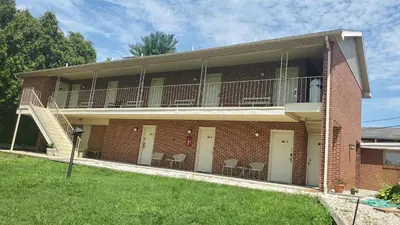 a brick building with a balcony with chairs on it at Travelodge by Wyndham Hershey in Hershey