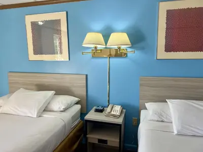 a hotel room with two beds and a phone on a table at Travelodge by Wyndham Hershey in Hershey