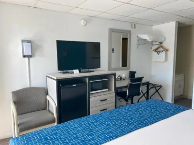 a hotel room with a bed and a flat screen tv at Travelodge by Wyndham Hershey in Hershey