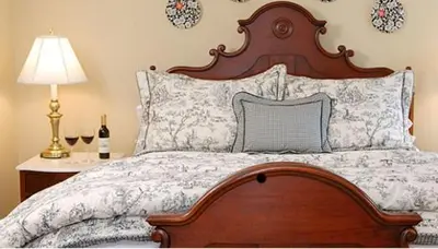 a bedroom with a bed with a wooden headboard and a lamp at Lambertville House in Lambertville