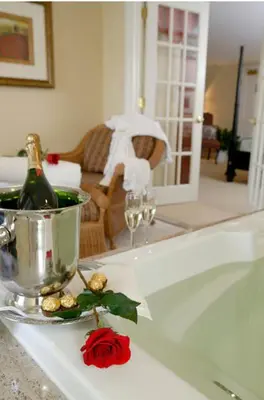 a white counter with a bottle of wine and a rose at Lambertville House in Lambertville