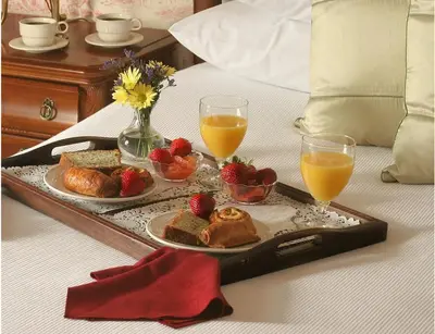 a tray of food on a bed with two glasses of orange juice at Lambertville House in Lambertville