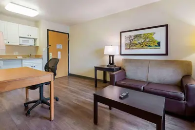 a living room with a couch and a table at Extended Stay America Suites - Piscataway - Rutgers University in Randolphville
