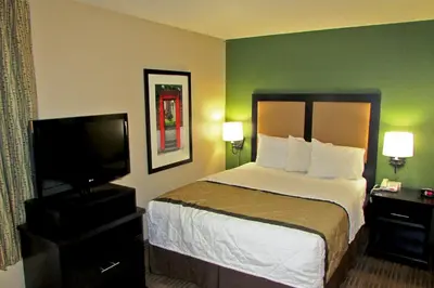 a hotel room with a bed and a flat screen tv at Extended Stay America Suites - Piscataway - Rutgers University in Randolphville