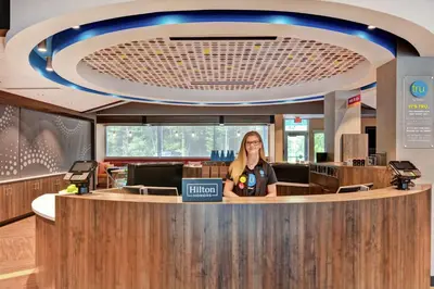 a woman standing at a counter in a lobby at Tru By Hilton Middletown in Middletown