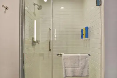 a shower with a glass door with a towel at Tru By Hilton Middletown in Middletown