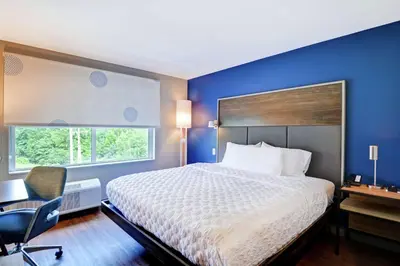 a hotel room with a bed and a desk and a window at Tru By Hilton Middletown in Middletown