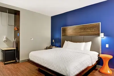a bedroom with a large bed with a blue wall at Tru By Hilton Middletown in Middletown