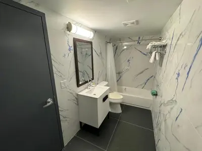 a bathroom with a sink and a toilet and a tub at Essence Express Elizabeth EWR Airport in Elizabeth