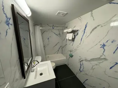 a bathroom with a white and blue marble wall at Essence Express Elizabeth EWR Airport in Elizabeth