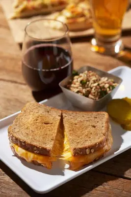 a sandwich on a plate with a salad and a glass of wine at Hyatt House Mount Laurel in Mount Laurel