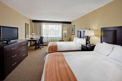 a hotel room with two beds and a flat screen tv at Radisson Hotel Freehold in Freehold