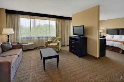 a hotel room with a couch and a bed and a television at Radisson Hotel Freehold in Freehold