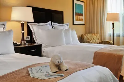 a teddy bear sitting on a bed in a hotel room at Radisson Hotel Freehold in Freehold