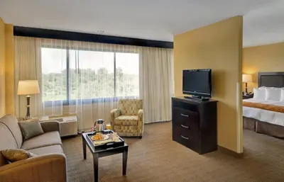 a hotel room with a bed and a flat screen tv at Radisson Hotel Freehold in Freehold