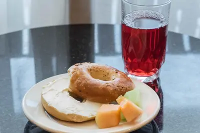 a plate of food with a donut and a drink at Radisson Hotel Freehold in Freehold