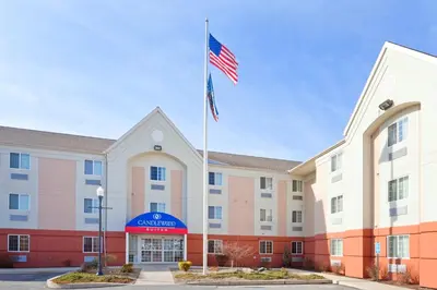 an exterior view of a hotel with an american flag at Candlewood Williamsport by IHG in Williamsport