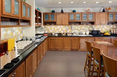 a large kitchen with wooden cabinets and a bar at Hyatt Place Princeton in Princeton