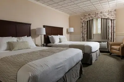 a hotel room with two beds and a chair at Bird-in-Hand Family Inn in Bird in Hand
