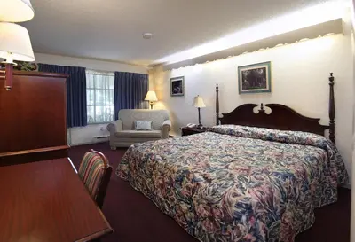 a hotel room with a bed and a chair at Bird-in-Hand Family Inn in Bird in Hand