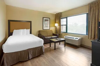 a hotel room with a bed and a chair at Extended Stay America Suites - Meadowlands - Rutherford in Rutherford