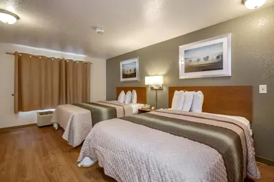 a hotel room with two beds and a window at HomeTowne Studios by Red Roof Philadelphia - Maple Shade, NJ in Maple Shade