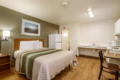 a hotel room with a bed and a desk and a kitchen at HomeTowne Studios by Red Roof Philadelphia - Maple Shade, NJ in Maple Shade