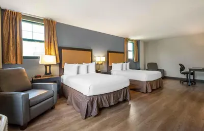 a hotel room with two beds and a chair at Extended Stay America Suites - Philadelphia - Plymouth Meeting - East in Plymouth Meeting
