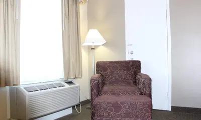 a chair sitting in a room next to a window at Quality Inn & Suites Williamsport in Williamsport