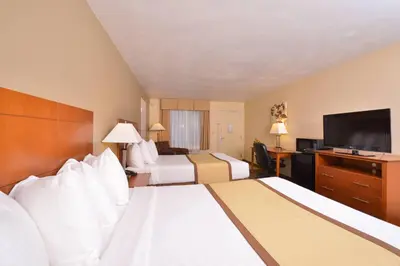 a hotel room with two beds and a flat screen tv at Quality Inn & Suites Williamsport in Williamsport