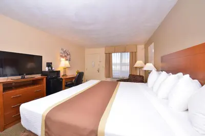 a hotel room with a large bed and a flat screen tv at Quality Inn & Suites Williamsport in Williamsport