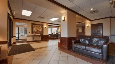 a waiting room with a leather couch in a lobby at Quality Inn & Suites Williamsport in Williamsport