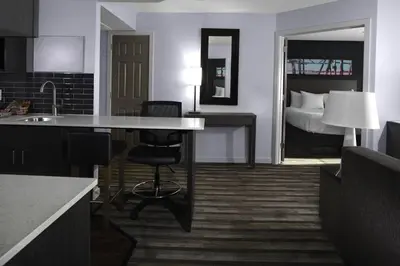 a room with a kitchen and a bedroom with a bed at Hyatt House Parsippany Whippany in Whippany