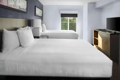 a hotel room with a large white bed and a window at Hyatt House Parsippany Whippany in Whippany