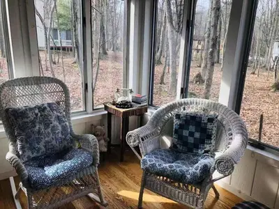 two chairs sitting in a room with windows at My Little Flagship Cabin in East Stroudsburg
