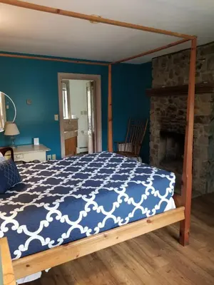 a bedroom with a bed with a blue and white comforter at Hawk Mountain Bed & Breakfast in Kempton