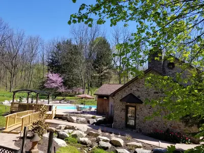 a stone building with a swimming pool in a yard at Hawk Mountain Bed & Breakfast in Kempton