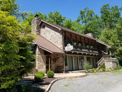 an exterior view of a stone house with a balcony at Hawk Mountain Bed & Breakfast in Kempton