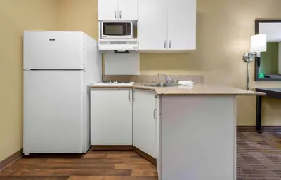 a kitchen with white cabinets and a white refrigerator at Extended Stay America Suites - Secaucus - Meadowlands in Secaucus