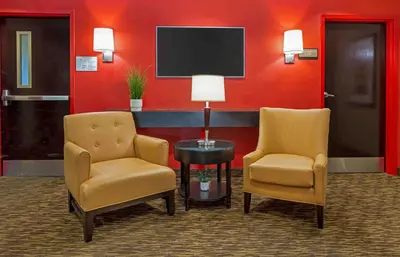 two chairs and a table in a room with a tv at Extended Stay America Suites - Secaucus - Meadowlands in Secaucus