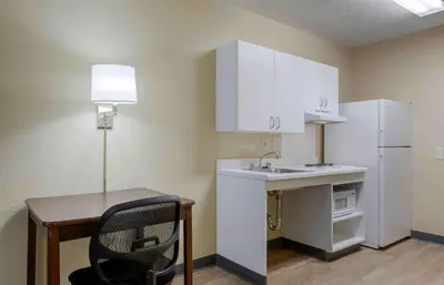 a small kitchen with a desk and a white refrigerator at Extended Stay America Suites - Hanover - Parsippany in Whippany