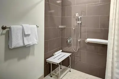 a bathroom with a shower with a stool in it at Hyatt House Branchburg - Bridgewater in Branchburg Park
