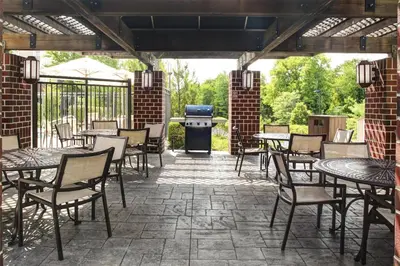a patio with tables and chairs and a grill at Hyatt House Branchburg - Bridgewater in Branchburg Park