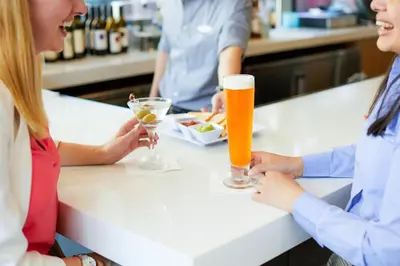 two women sitting at a table with drinks at Hyatt House Branchburg - Bridgewater in Branchburg Park